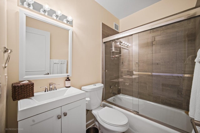 full bathroom featuring shower / bath combination with glass door, vanity, and toilet