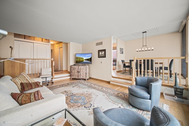 living room with light wood-type flooring and a notable chandelier