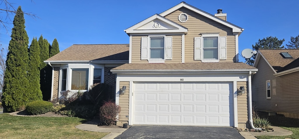 view of front of home featuring a front yard and a garage