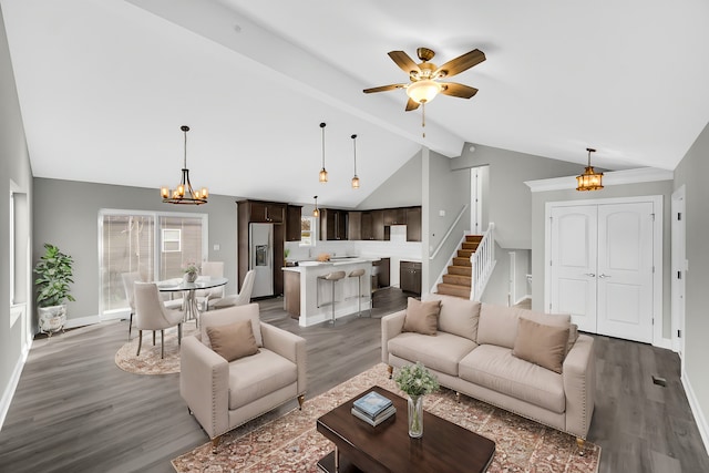 living room featuring ceiling fan with notable chandelier, wood-type flooring, and vaulted ceiling with beams