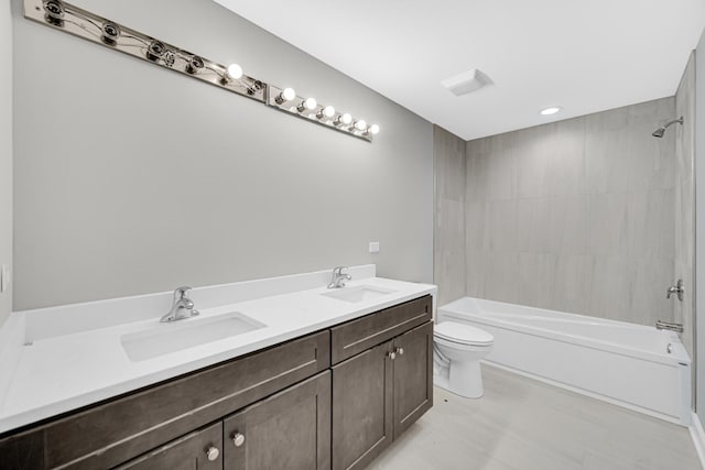 full bathroom featuring toilet, tiled shower / bath, and vanity