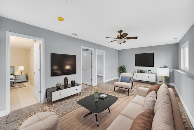 living room featuring light wood-type flooring and ceiling fan