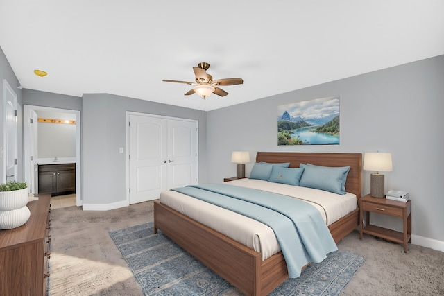 bedroom featuring ceiling fan, a closet, ensuite bath, and carpet floors