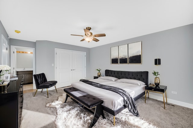 carpeted bedroom with ceiling fan, a closet, and ensuite bath