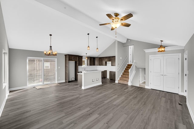 unfurnished living room with ceiling fan with notable chandelier, dark hardwood / wood-style flooring, and lofted ceiling with beams