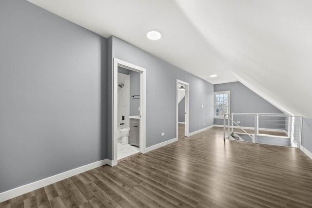 additional living space with hardwood / wood-style flooring and lofted ceiling