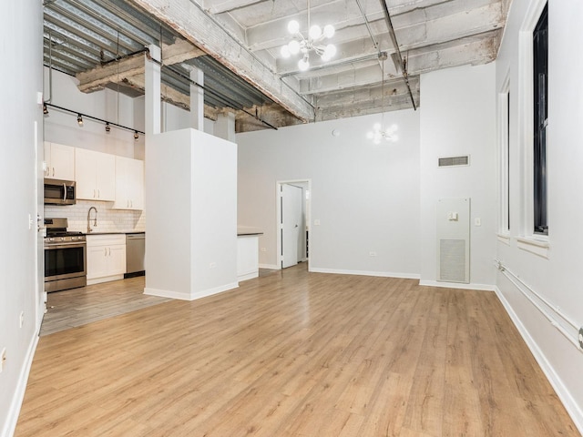 basement with sink, a notable chandelier, and light wood-type flooring