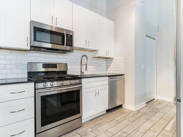 kitchen featuring white cabinetry, sink, stainless steel appliances, and light hardwood / wood-style flooring