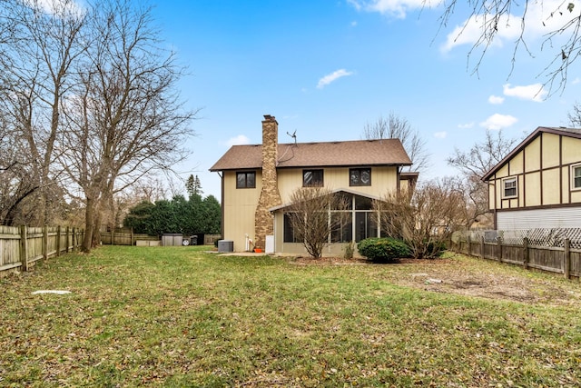 rear view of property featuring a lawn, a sunroom, and central AC unit