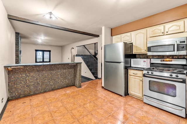 kitchen with cream cabinets, stainless steel appliances, and beam ceiling