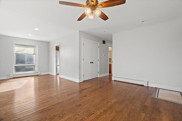 spare room with wood-type flooring, a baseboard radiator, and ceiling fan