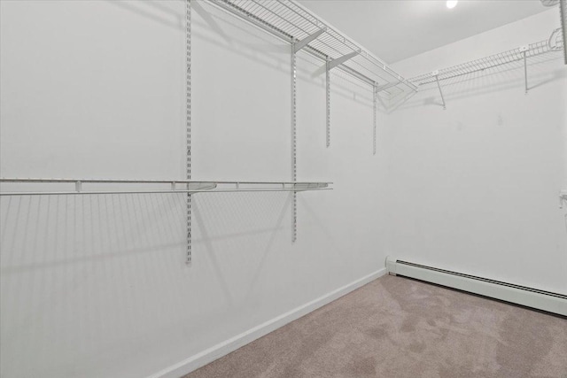 spacious closet with carpet flooring and baseboard heating