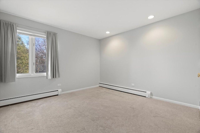 carpeted empty room featuring a baseboard heating unit