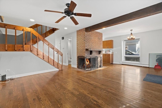 unfurnished living room with hardwood / wood-style flooring, ceiling fan, a fireplace, and beamed ceiling