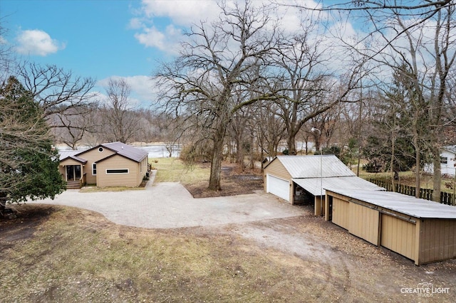 view of yard with a garage and an outbuilding