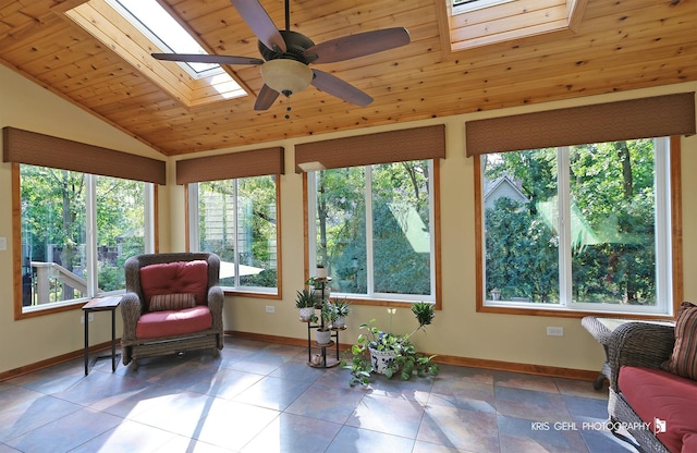 sunroom / solarium featuring ceiling fan, vaulted ceiling with skylight, and wood ceiling