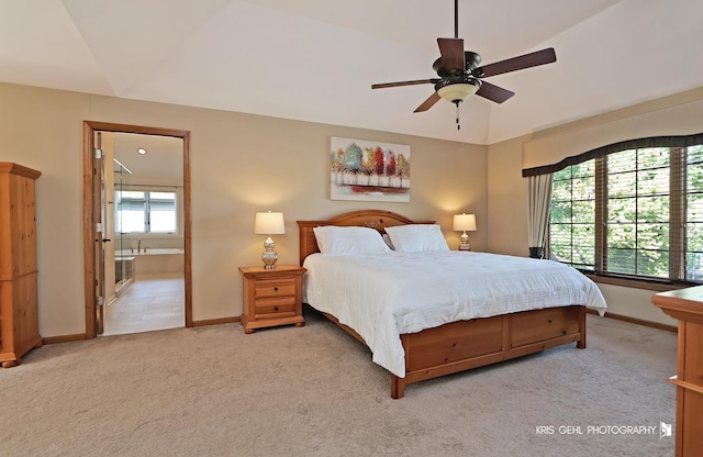 carpeted bedroom featuring ceiling fan, ensuite bath, and lofted ceiling