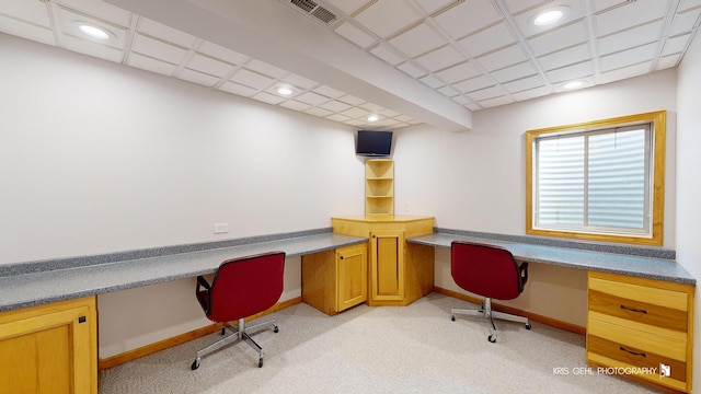 carpeted home office featuring built in desk