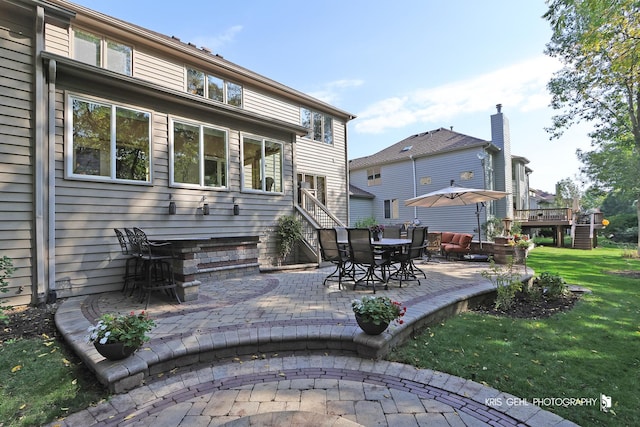 back of property with a yard and a patio