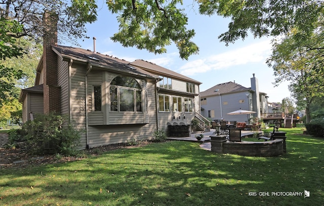 rear view of property featuring a lawn and a patio area