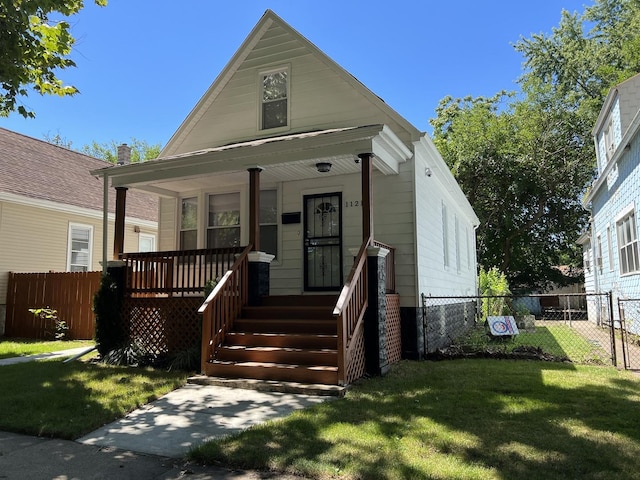 bungalow with covered porch and a front yard