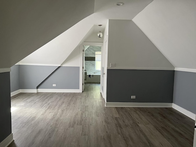 additional living space featuring dark hardwood / wood-style flooring and vaulted ceiling