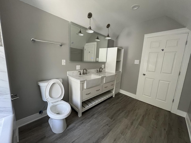 bathroom featuring toilet, vanity, lofted ceiling, and hardwood / wood-style flooring