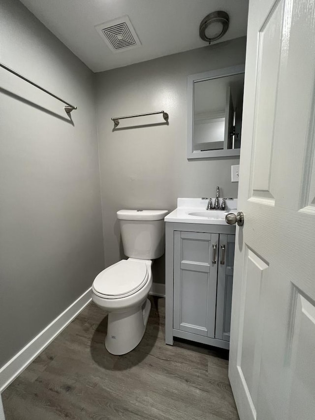 bathroom with vanity, toilet, and wood-type flooring