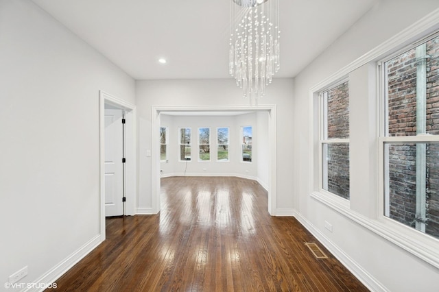 interior space featuring a notable chandelier and dark wood-type flooring