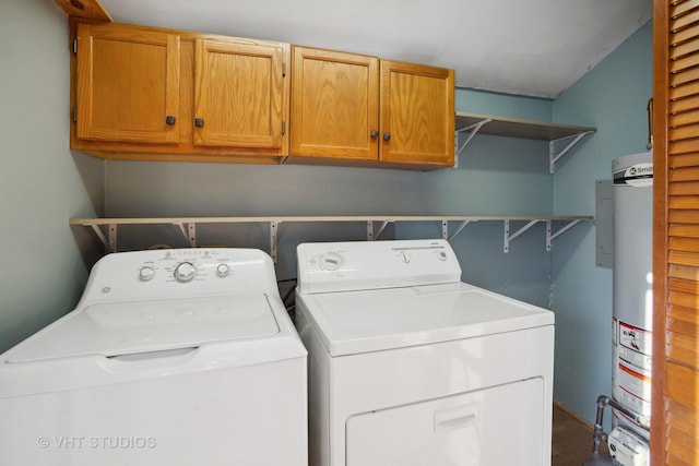 washroom with cabinets, washer and clothes dryer, and water heater