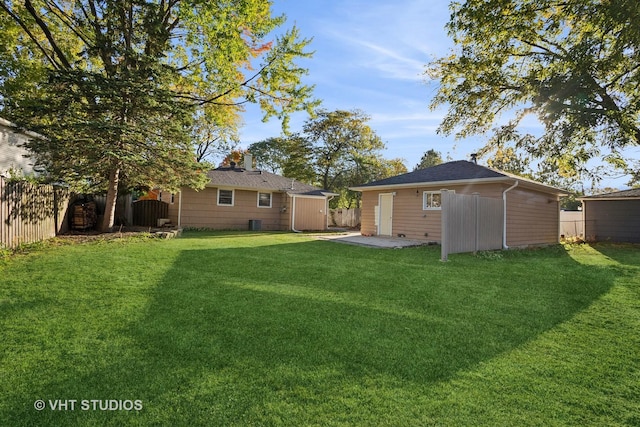 rear view of house with a lawn and an outdoor structure