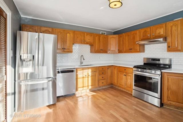 kitchen featuring stainless steel appliances, tasteful backsplash, crown molding, and sink