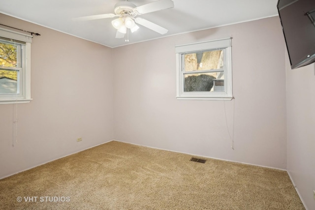 carpeted spare room featuring ceiling fan