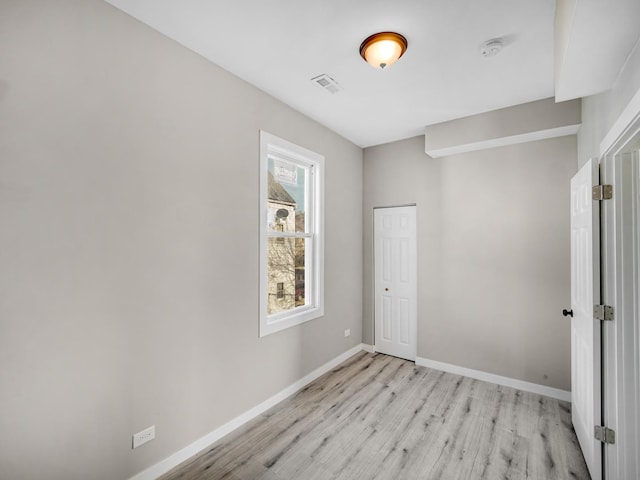 empty room with light hardwood / wood-style flooring