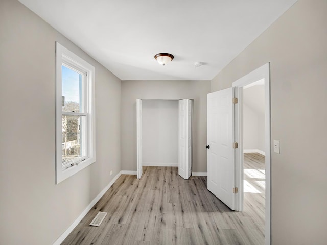 hallway with light hardwood / wood-style floors