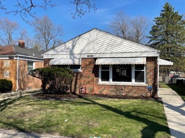 view of side of property featuring brick siding and a lawn