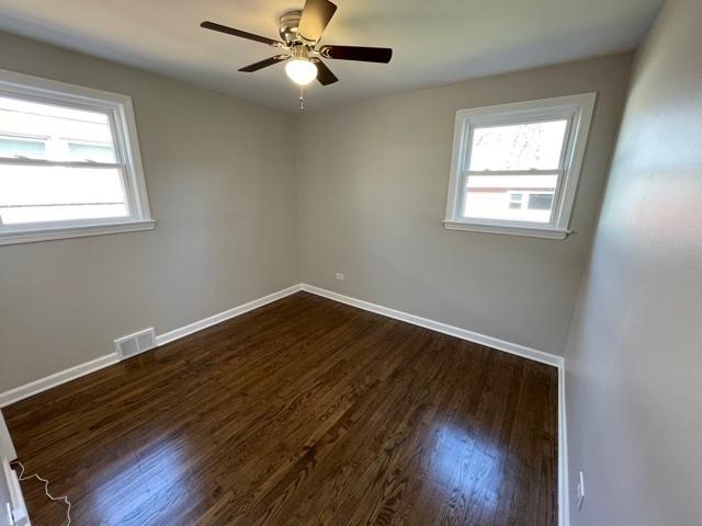 unfurnished room featuring a healthy amount of sunlight, visible vents, and baseboards