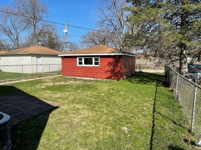 view of yard featuring an outbuilding, a shed, and a fenced backyard