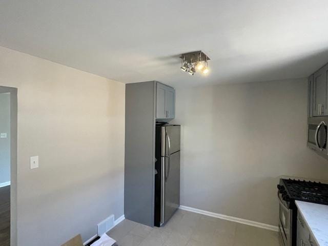 kitchen featuring visible vents, baseboards, light countertops, appliances with stainless steel finishes, and gray cabinets