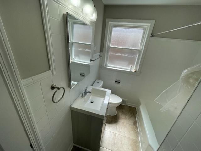 full bath with tile walls, tile patterned flooring, vanity, and toilet