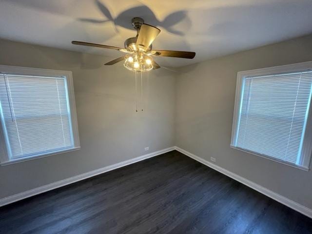 spare room featuring dark wood-type flooring, ceiling fan, and baseboards