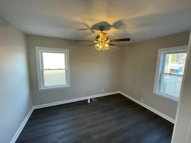 empty room with baseboards, dark wood finished floors, and a ceiling fan