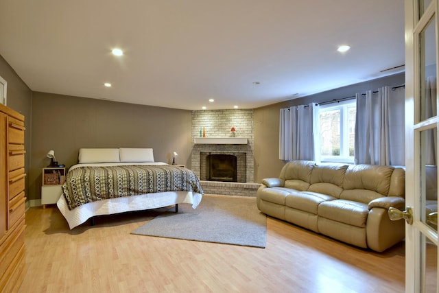 bedroom with a fireplace and light wood-type flooring