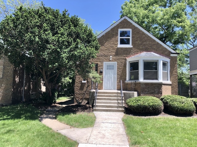 bungalow-style house featuring a front lawn and brick siding