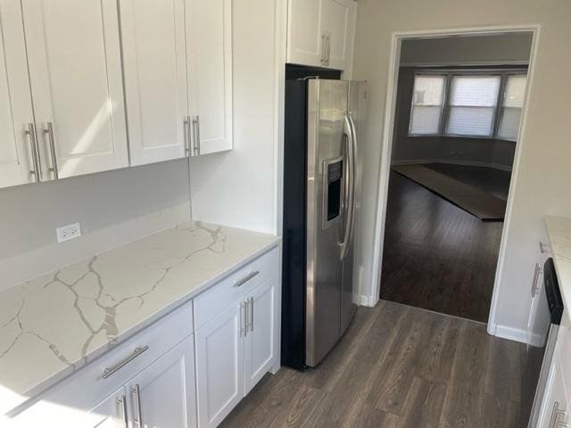 kitchen featuring light stone countertops, white cabinets, and stainless steel fridge with ice dispenser