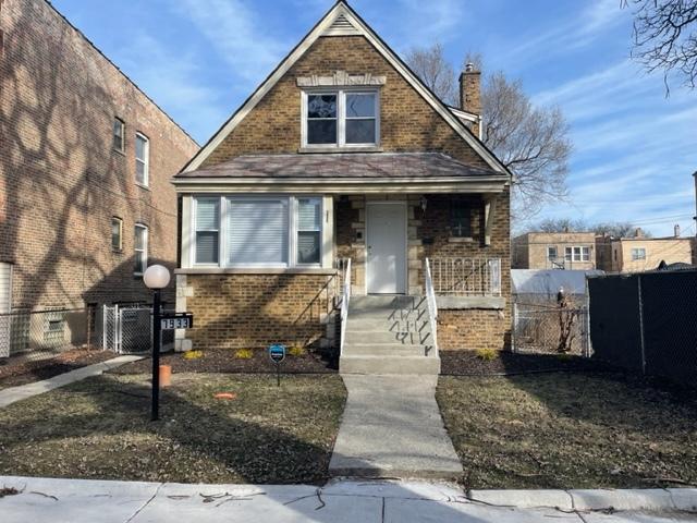 bungalow-style home featuring fence private yard, a chimney, covered porch, and brick siding