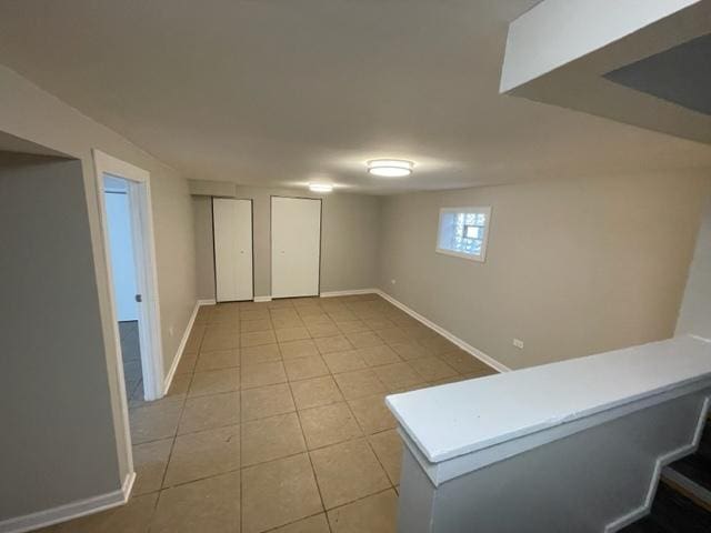 below grade area with light tile patterned floors and baseboards