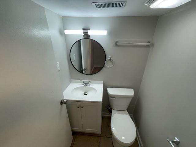 half bathroom with visible vents, vanity, and toilet