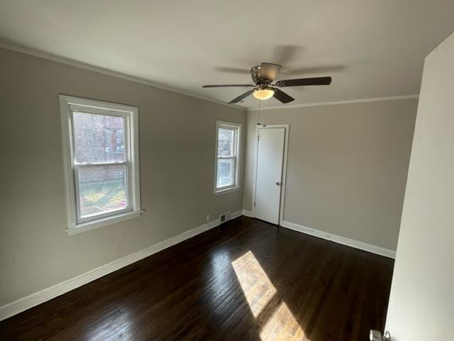 unfurnished room featuring dark wood-style floors, crown molding, baseboards, and a ceiling fan