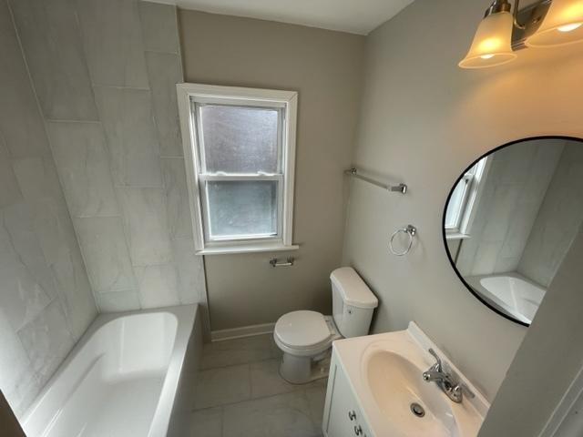 bathroom with toilet, tile patterned flooring, baseboards, and vanity